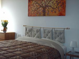 a bedroom with a bed with a painting on the wall at Guest House Cuore del Friuli in Udine