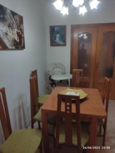 una sala da pranzo con tavolo e sedie in legno di Apartamento VILLA INÉS parking y wifi gratis a Huércal de Almería