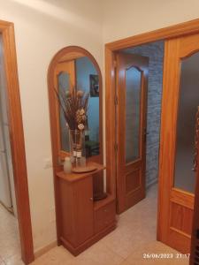 un pasillo con una puerta de madera y un jarrón con flores en un jarrón en Apartamento VILLA INÉS parking y wifi gratis, en Huércal de Almería