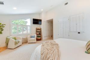 1 dormitorio blanco con 1 cama y 2 sillas en Commodore Bay Waterfront Home on Lake Norman!, en Mooresville