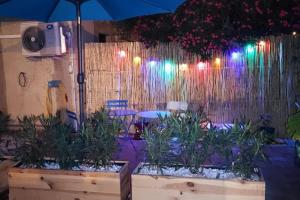 een patio met een hek met verlichting en planten bij Appartement cosy sur Agde pour 4 personnes maxi. in Agde