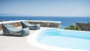 una piscina con sedie e l'oceano sullo sfondo di Elia Spirit Villas and Suites by Live&Travel a Elia Beach