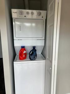 um frigorífico branco com um micro-ondas e uma garrafa vermelha em Appleberry enterprise em Owings Mills