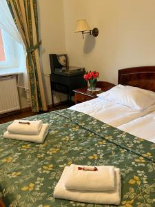 a hotel room with two beds with towels on them at Aparthotel Karmel in Kraków