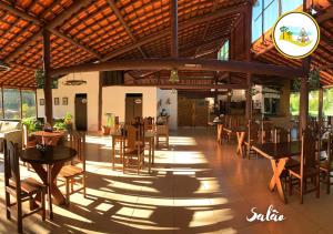 a dining room with tables and chairs in a building at Estância das Nascentes in Salesópolis