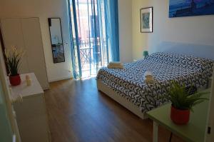 a bedroom with a bed and a door to a balcony at La Dimora dell'Arcivescovo in Bari