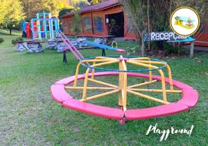 eine Spielausrüstung im Gras mit Spielplatz in der Unterkunft Estância das Nascentes in Salesópolis