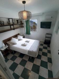 1 dormitorio con 1 cama y suelo a cuadros en room private bathroom in shared apartment 50m from Gibraltar en La Línea de la Concepción