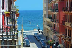 eine Stadtstraße mit Autos auf der Seite des Ozeans in der Unterkunft La Dimora dell'Arcivescovo in Bari