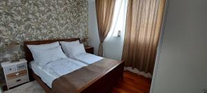 Un dormitorio con una cama y una ventana en Nota Apartman, en Vrnjačka Banja