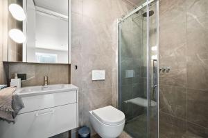 een badkamer met een douche, een toilet en een wastafel bij Private Lux 2BR & 2BA City Center with Free Parking in Reykjavík
