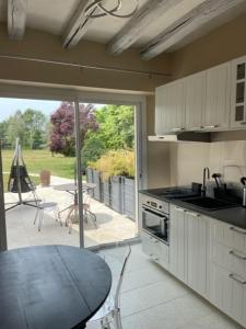 eine Küche mit Blick auf eine Terrasse mit einem Tisch in der Unterkunft GITE ROMANTIQUE in Cléré-les-Pins
