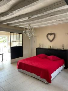 ein Schlafzimmer mit einem roten Bett mit einem Herz an der Wand in der Unterkunft GITE ROMANTIQUE in Cléré-les-Pins
