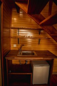 - une cuisine avec évier dans une chambre dotée de murs en bois dans l'établissement Ayliya bungalow, à Trabzon