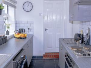a kitchen with a counter and a clock on the wall at Templar House - Sleeps 6, Special Weekly Monthly Stay Rates, Central Location with FREE Parking, FREE WiFi, Perfect for ALTON TOWERS & M6 in Stoke on Trent