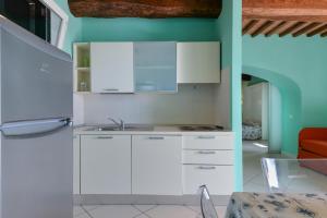 a kitchen with white cabinets and a blue wall at Appartamento sul Mare a Rio Marina, Isola d'Elba in Rio Marina