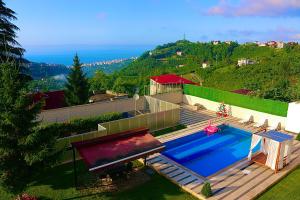 une piscine avec une terrasse et une maison dans l'établissement Ak Nature Suites Villa, à Trabzon