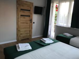 ein Schlafzimmer mit 2 Betten und eine Tür mit Handtüchern in der Unterkunft Zielony Zakątek Przeciszów Zator in Przeciszów