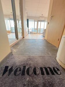 una alfombra de bienvenida en el suelo de un vestíbulo de oficina en Krasta Home apartament Free Parking With CITY & RIVER VIEW, en Riga