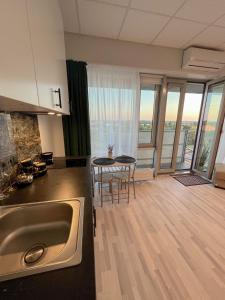 a kitchen with a sink and a table with chairs at Krasta Home apartament Free Parking With CITY & RIVER VIEW in Rīga