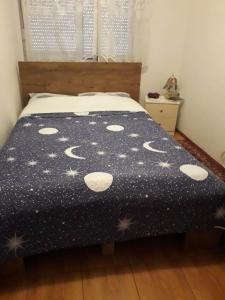 a bed with a black comforter with stars on it at Apartman Katarina in Vranje
