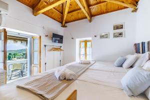 ein großes weißes Schlafzimmer mit einem großen Bett und einem Balkon in der Unterkunft Christina's Cottage in Skopelos