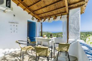einen Tisch und Stühle auf einer Terrasse mit Aussicht in der Unterkunft Christina's Cottage in Skopelos