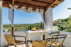 ein Tisch und Stühle auf einem Balkon mit Aussicht in der Unterkunft Christina's Cottage in Skopelos