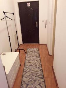 a hallway with a black door with a rug in front at Apartman Katarina in Vranje
