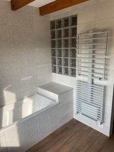 een witte badkamer met een bad en een raam bij Maison de campagne rénovée 