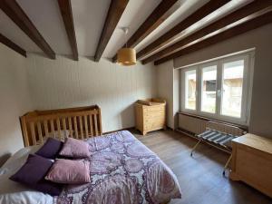 een slaapkamer met een bed met paarse kussens bij Maison de campagne rénovée 