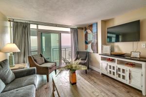 a living room with a couch and a tv at Oceanfront Myrtle Beach Condo with Pools and Hot Tubs in Myrtle Beach