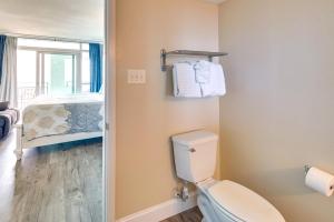 a bathroom with a toilet and a bedroom with a bed at Oceanfront Myrtle Beach Condo with Pools and Hot Tubs in Myrtle Beach