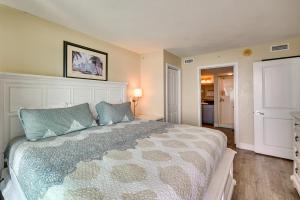a bedroom with a large bed with blue pillows at Oceanfront Myrtle Beach Condo with Pools and Hot Tubs in Myrtle Beach