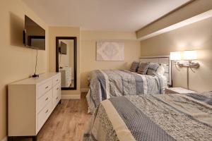 a hotel room with two beds and a television at Oceanfront Myrtle Beach Condo with Pools and Hot Tubs in Myrtle Beach