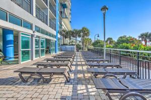 a row of benches in front of a building at Oceanfront Myrtle Beach Condo with Pools and Hot Tubs in Myrtle Beach