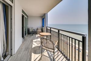 a balcony with a table and chairs and the ocean at Oceanfront Myrtle Beach Condo with Pools and Hot Tubs in Myrtle Beach