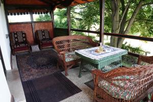 een afgeschermde veranda met een tafel en stoelen bij Etno House BORAK in Kladušnica