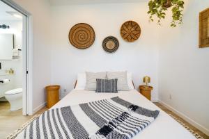 ein Schlafzimmer mit einem weißen Bett mit einer schwarzen und weißen Decke in der Unterkunft Redwood City Escape with Big-Screen TV! in Redwood City