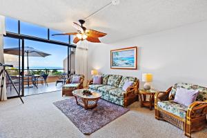 Kahana Villa E701 في Kapalua-West Maui Airport: غرفة معيشة مع أريكة وكراسي وطاولة