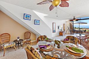 a living room with a table and chairs at Kahana Villa E701 in Kahana