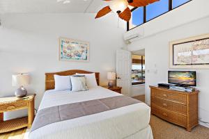 a bedroom with a large bed and a ceiling fan at Kahana Villa E701 in Kahana +26 photos