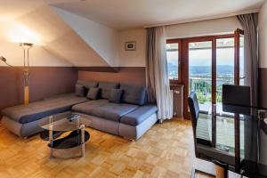 a living room with a couch and a table and a television at Sun & See in Velden am Wörthersee