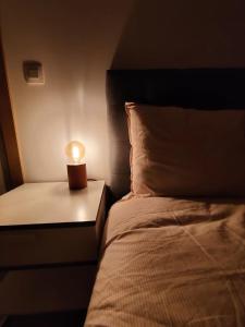 a bed with a small lamp on a night stand at Bel-etage Bruges Homestay - Free parking - Entire floor in Bruges