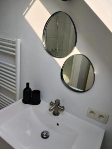 een wastafel in de badkamer met 2 spiegels aan de muur bij Bel-etage Bruges Homestay - Free parking - Entire floor in Brugge
