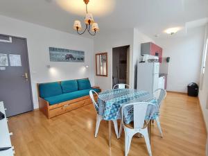 ein Wohnzimmer mit einem blauen Sofa und einem Tisch in der Unterkunft L'Isard, T2, centre Luchon, wifi, ascenseur, casier à ski, 4 personnes in Luchon