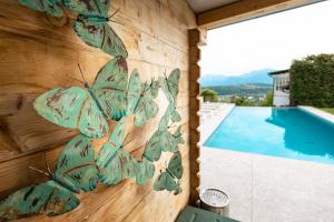 uma parede com borboletas pintadas ao lado de uma piscina em Sun & See em Velden am Wörthersee