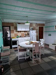 a kitchen with a white table and chairs in it at ALOJAMIENTO SERRANO in Villa Giardino