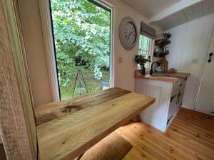 a kitchen with a counter and a large window at Cornwall Woodland Dog Friendly Shepherd's Hut in Bodmin