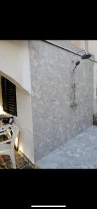 um quarto com uma parede de pedra e um chuveiro em Mondeno house em Utjeha